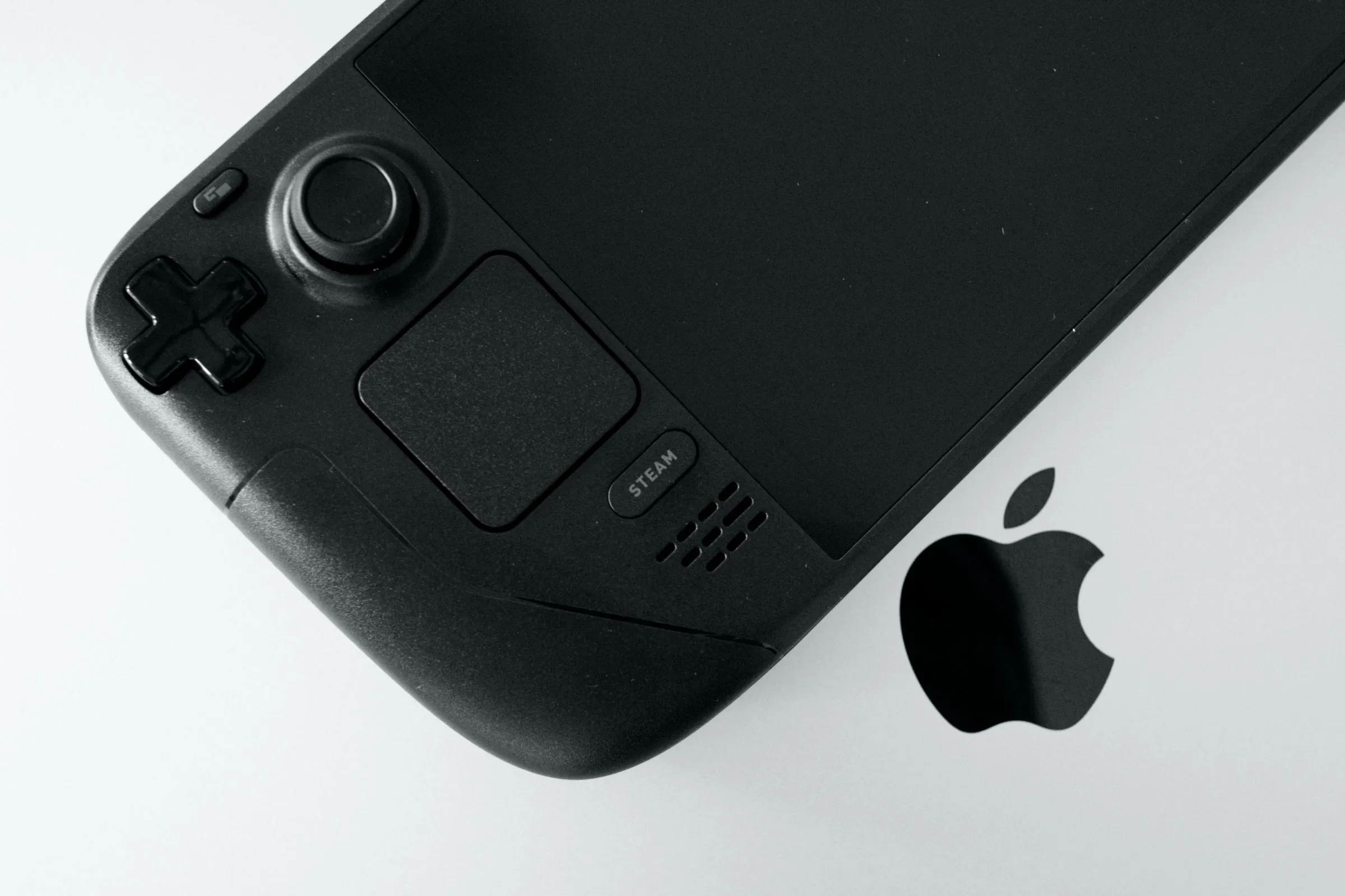 Steam Deck OLED đặt trên một chiếc MacBook Pro đang điều khiển SteamOS
