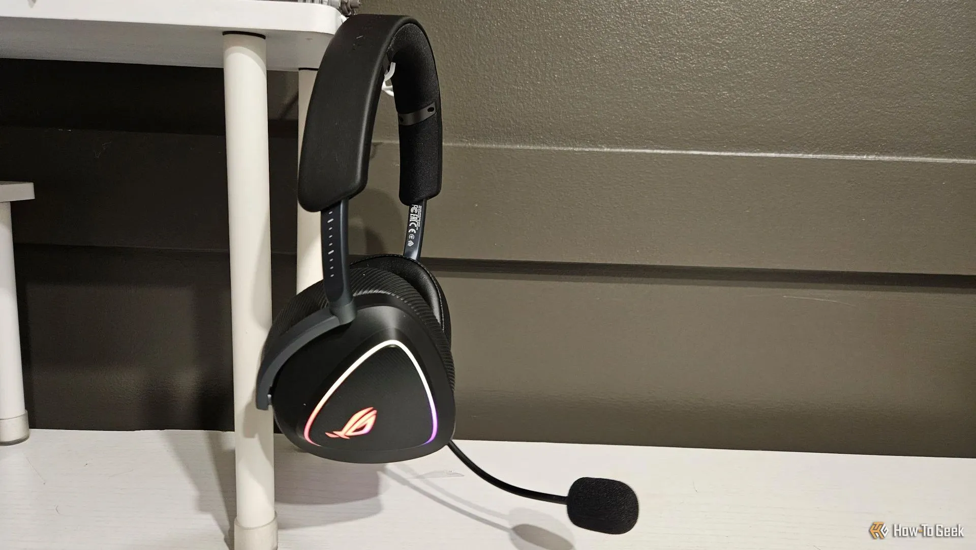 Tai nghe ASUS ROG Delta II được treo trên giá đỡ bàn làm việc.