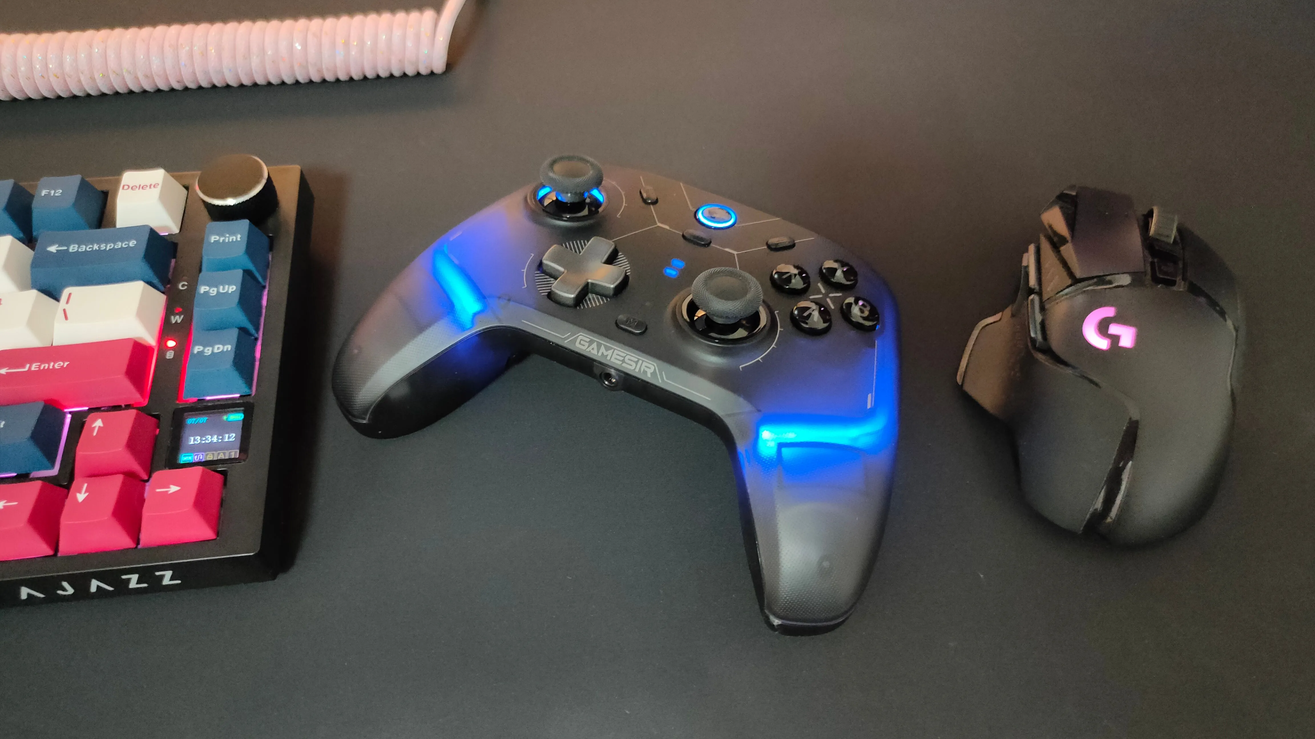 Tay cầm GameSir Cyclone 2 đặt giữa chuột gaming Logitech G502 và bàn phím cơ, thể hiện tính đa năng của tay cầm