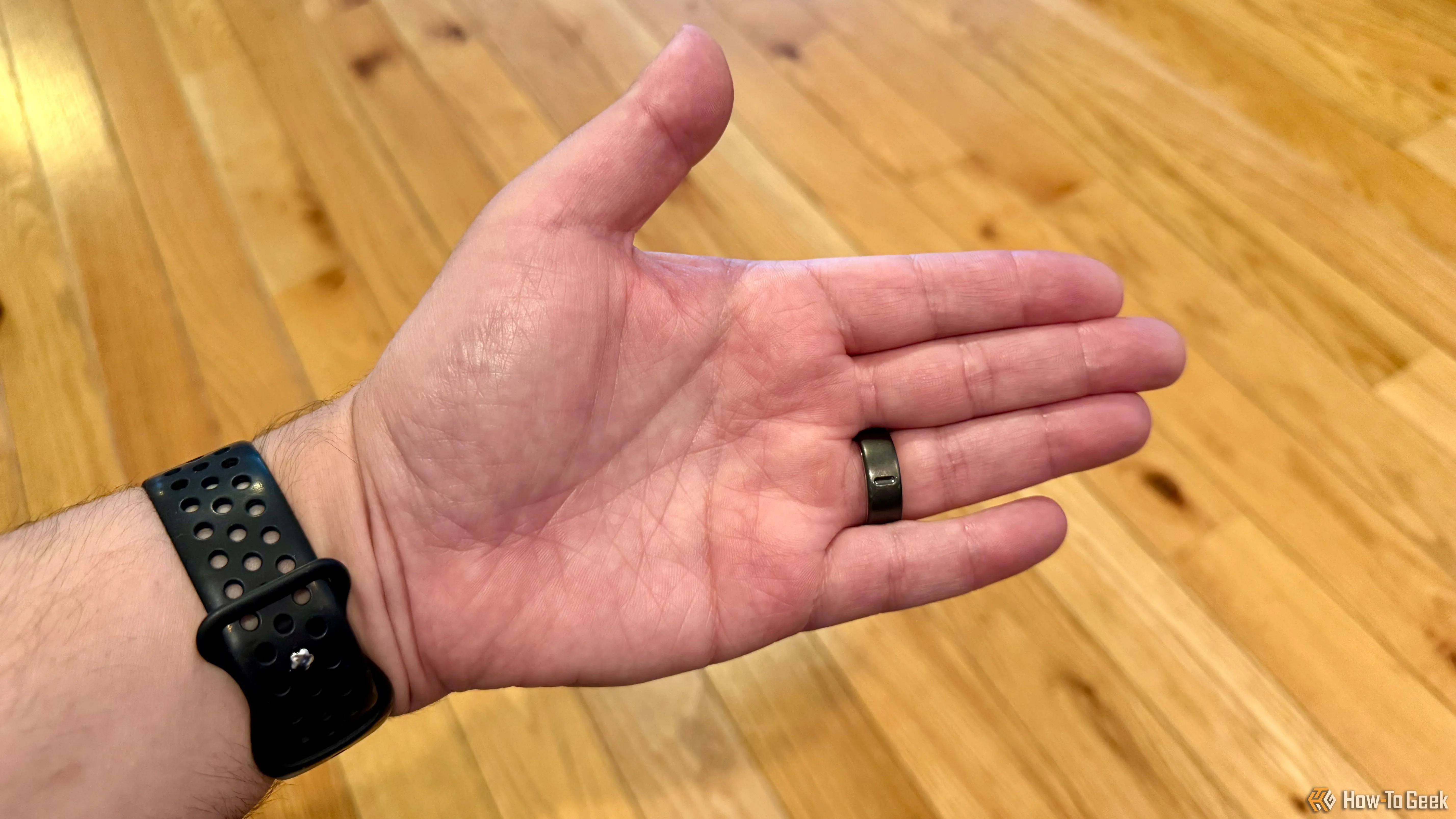 Thấy rõ mặt dưới của Oura Ring 4 khi đeo, nơi đặt các cảm biến liên tục theo dõi cơ thể.