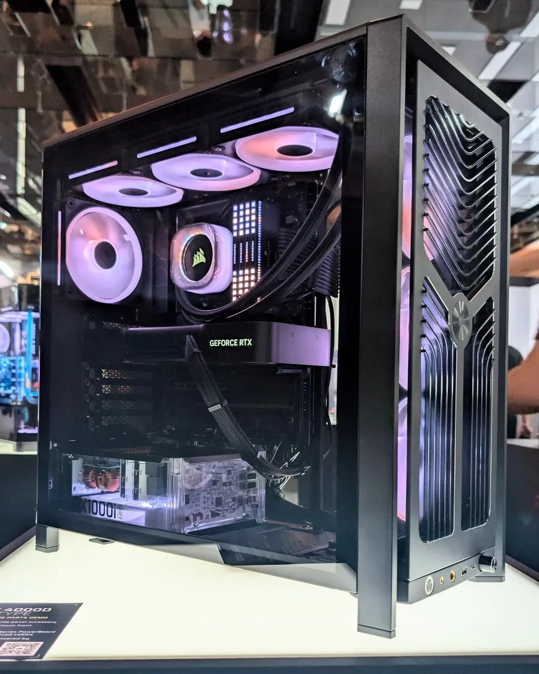 Thùng máy tính Corsair Frame 4000D trưng bày cùng bộ nguồn trong suốt HX1000i SHIFT, làm nổi bật hiệu ứng đèn RGB.