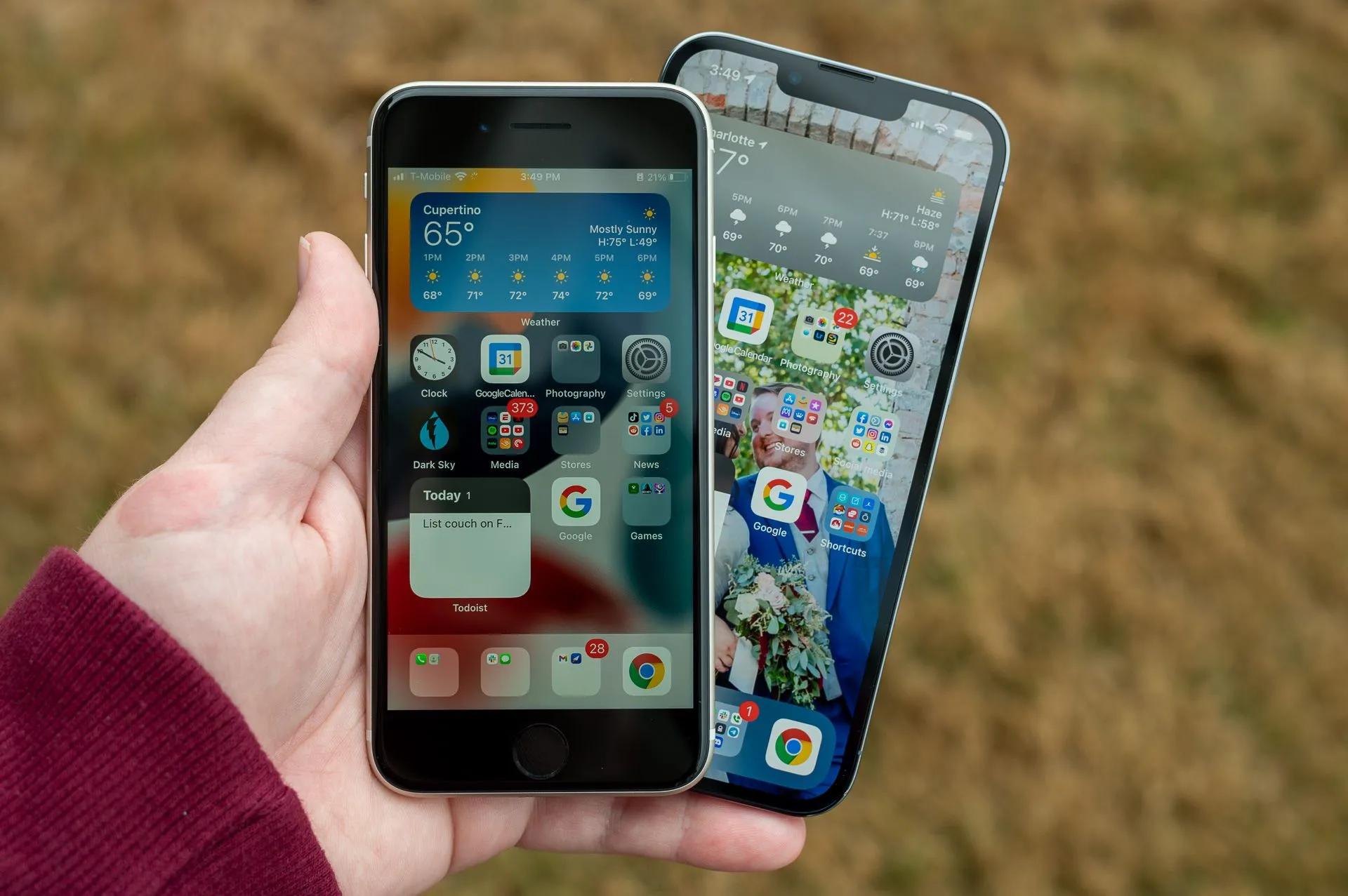 Một người đang cầm chiếc iPhone SE và iPhone 13 Pro