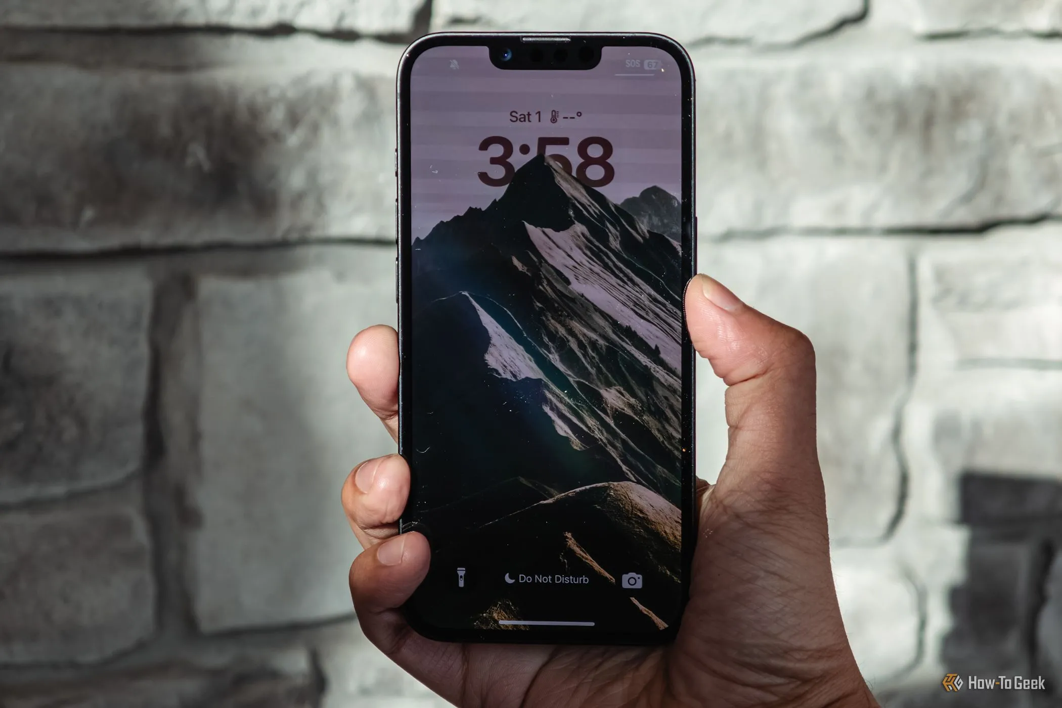 Người dùng cầm iPhone 16e với màn hình khóa đang hiển thị, cho thấy trải nghiệm xem nội dung ổn định trên tấm nền 6.1 inch