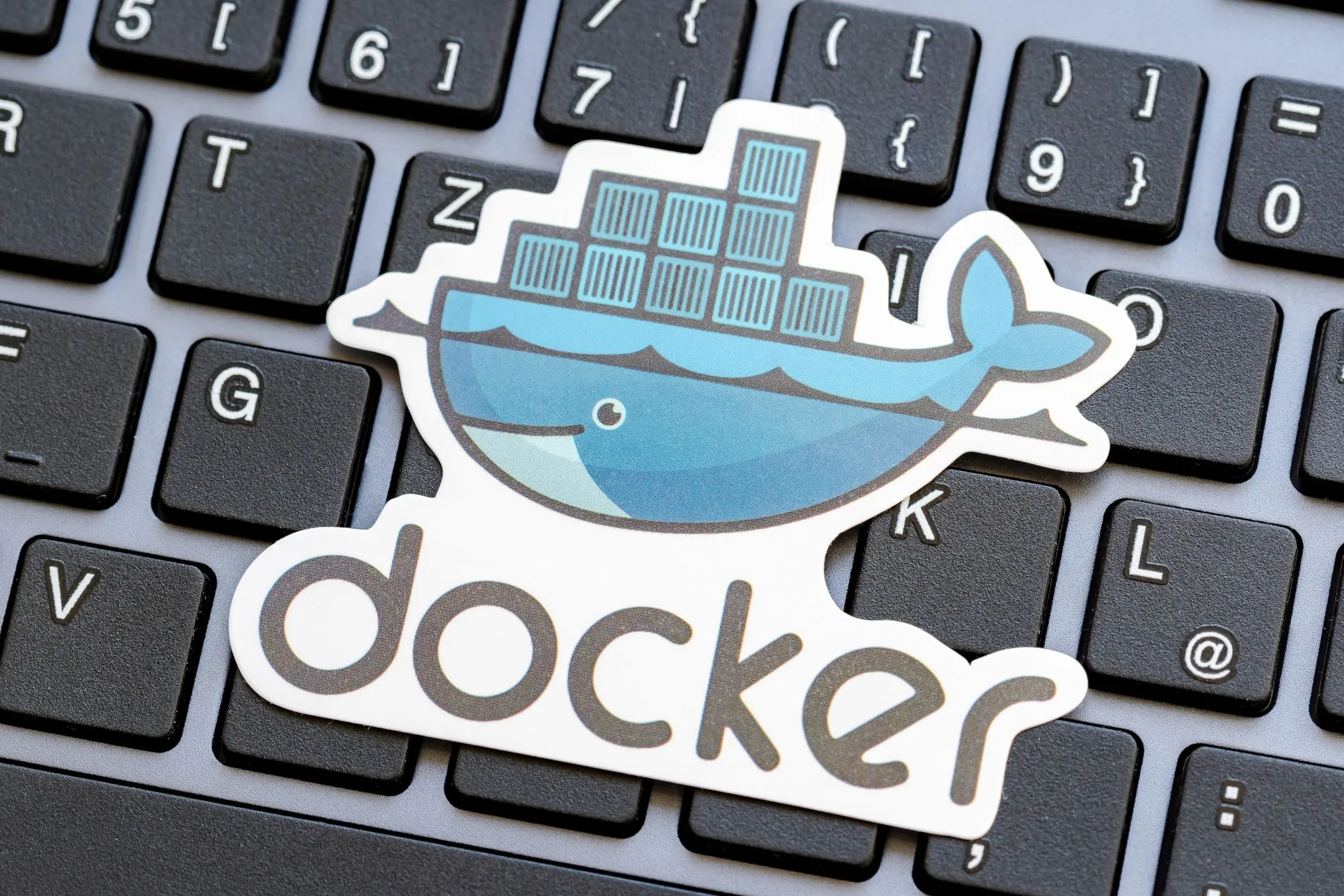 Logo Docker trên bàn phím laptop, biểu thị nền tảng container hóa cho việc triển khai website cá nhân.
