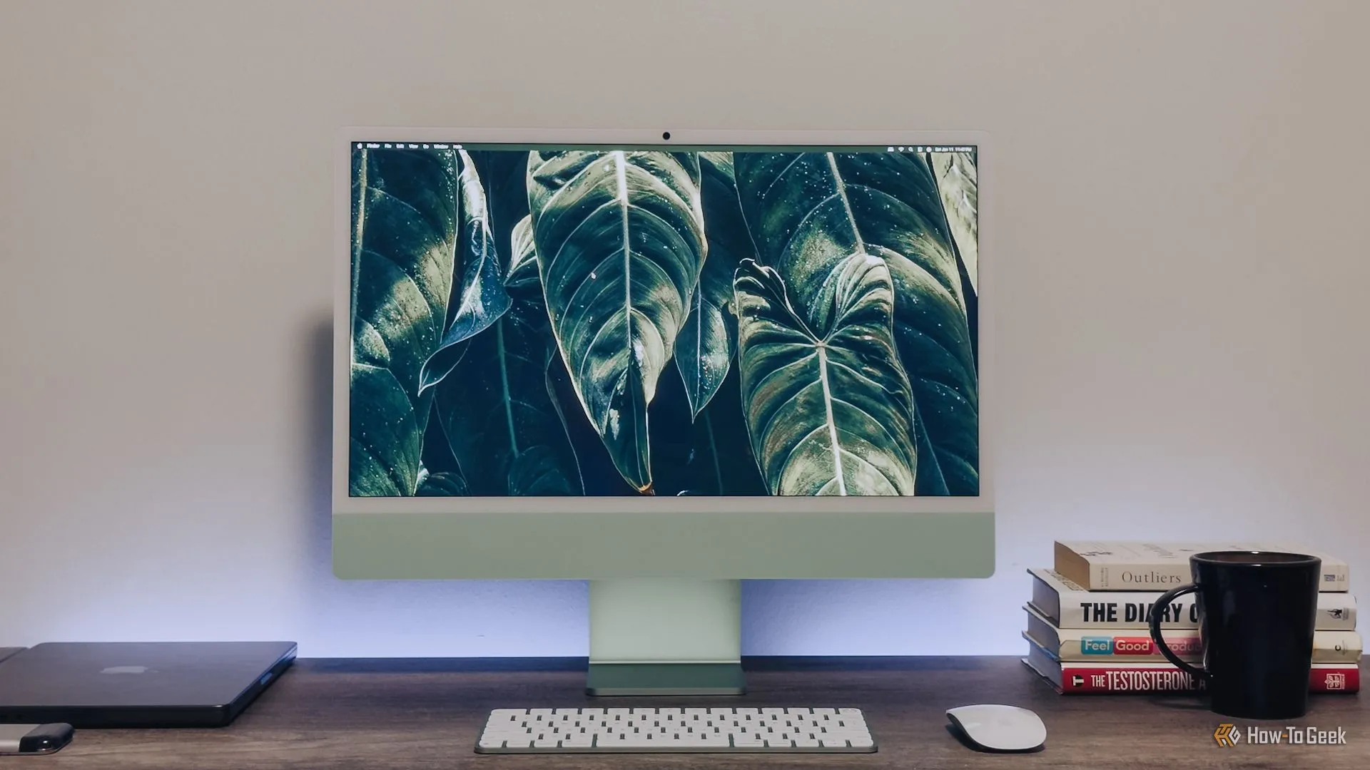 Một bộ máy tính iMac M4 màu xanh lá cây đầy đủ trên bàn làm việc, thể hiện thiết kế hiện đại.