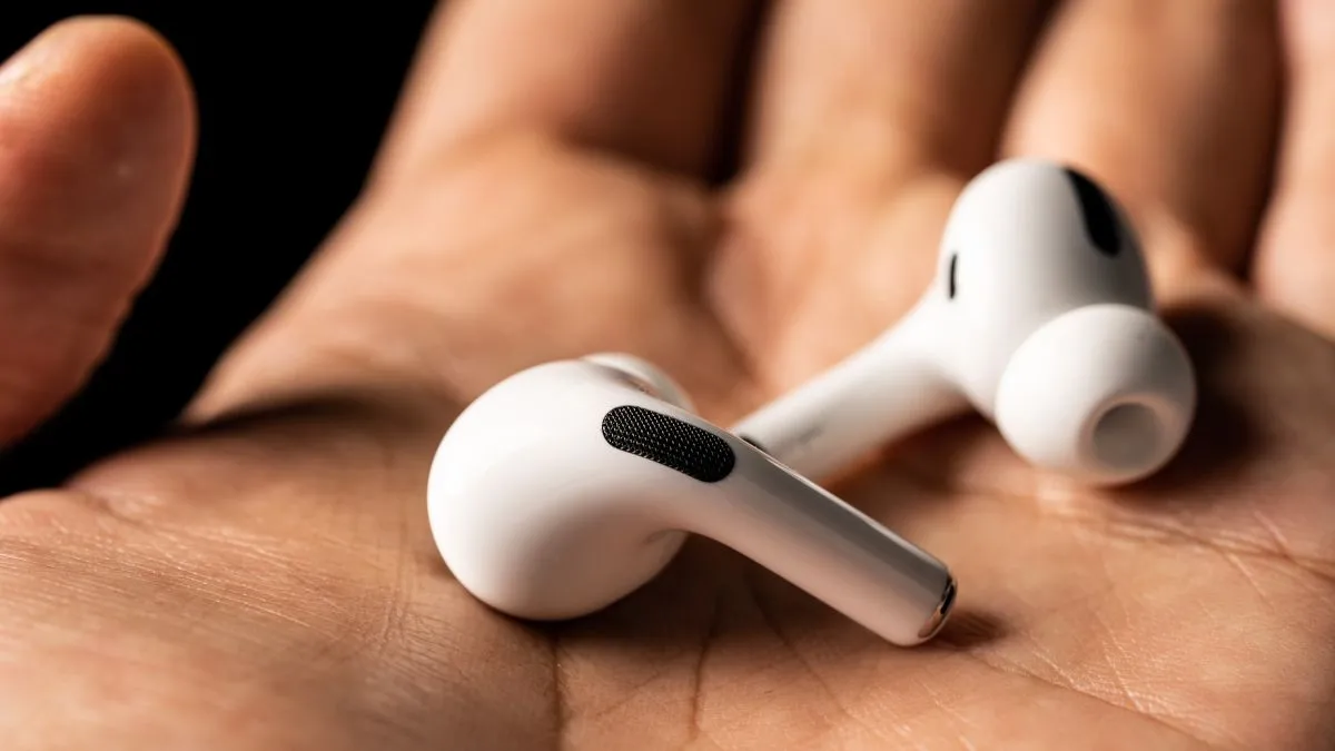Một cặp tai nghe AirPods đang được đeo trong tai một người, minh họa trải nghiệm sử dụng và vấn đề về sự thoải mái.