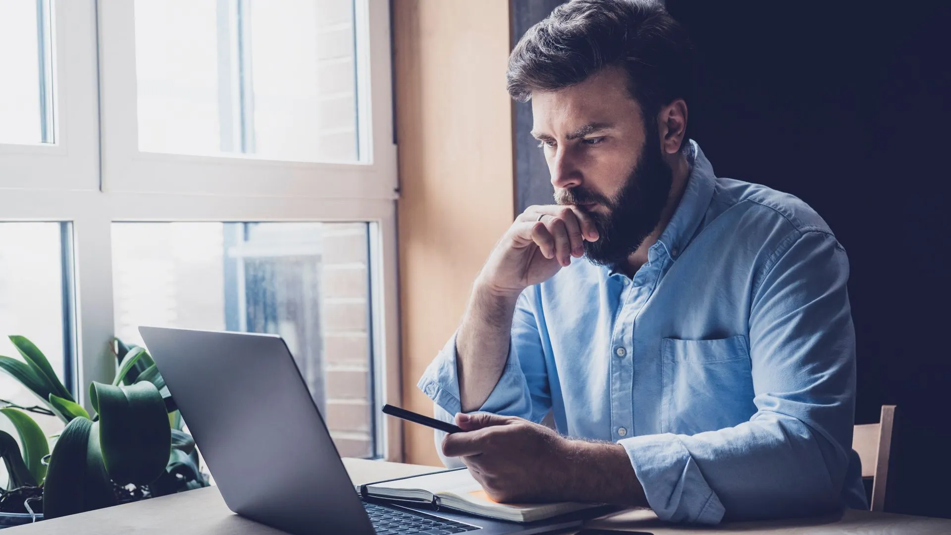 Một người đàn ông chuyên nghiệp đang làm việc trên laptop, tượng trưng cho sự nghiêm túc và uy tín khi sở hữu website cá nhân.