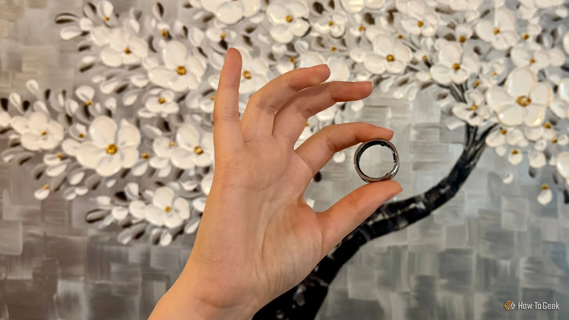 RingConn Gen 2 Air được cầm trong tay người dùng, thể hiện vẻ ngoài thanh lịch.