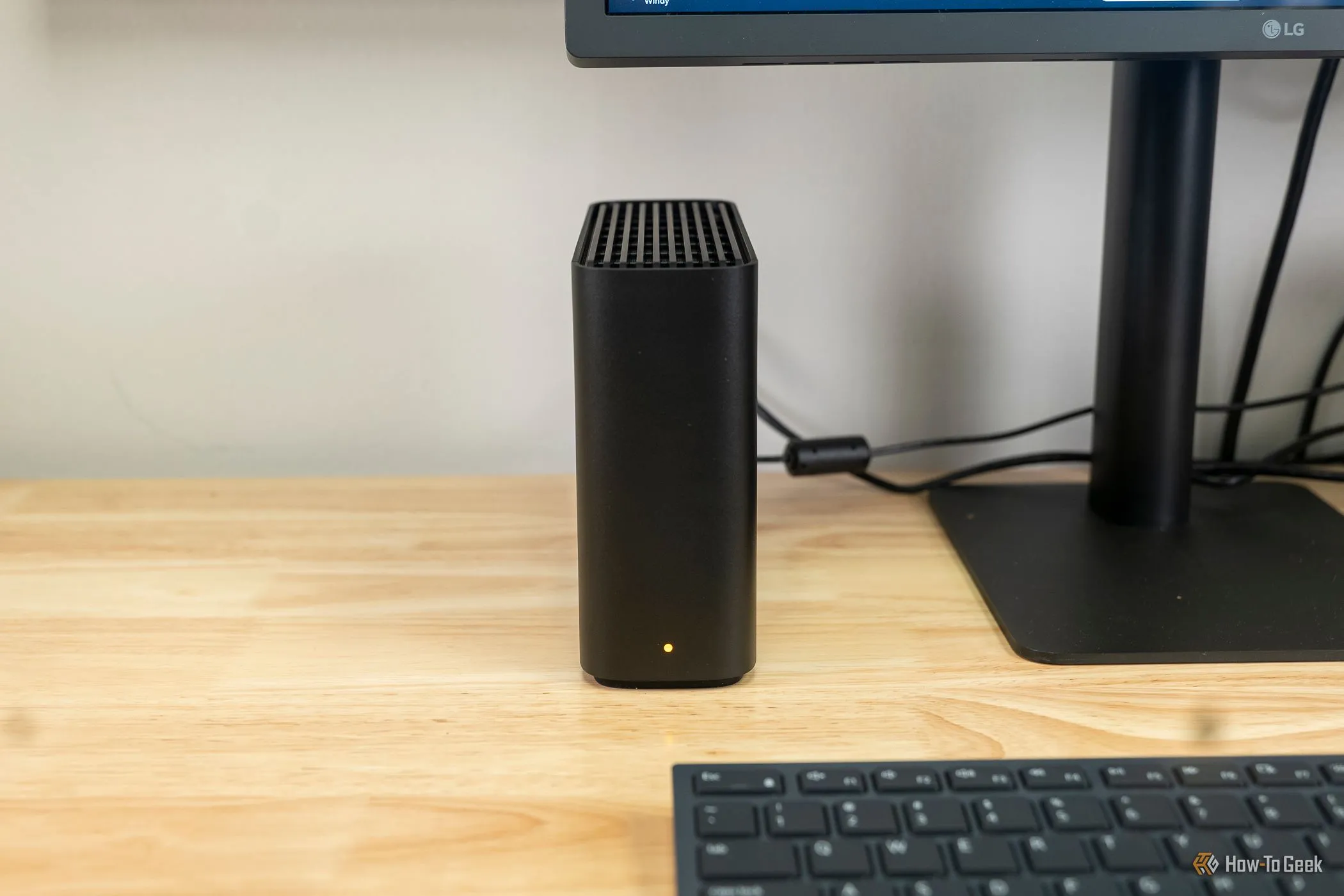 Synology BeeStation đặt cạnh màn hình máy tính, minh chứng cho một giải pháp lưu trữ gắn mạng thân thiện với người dùng.